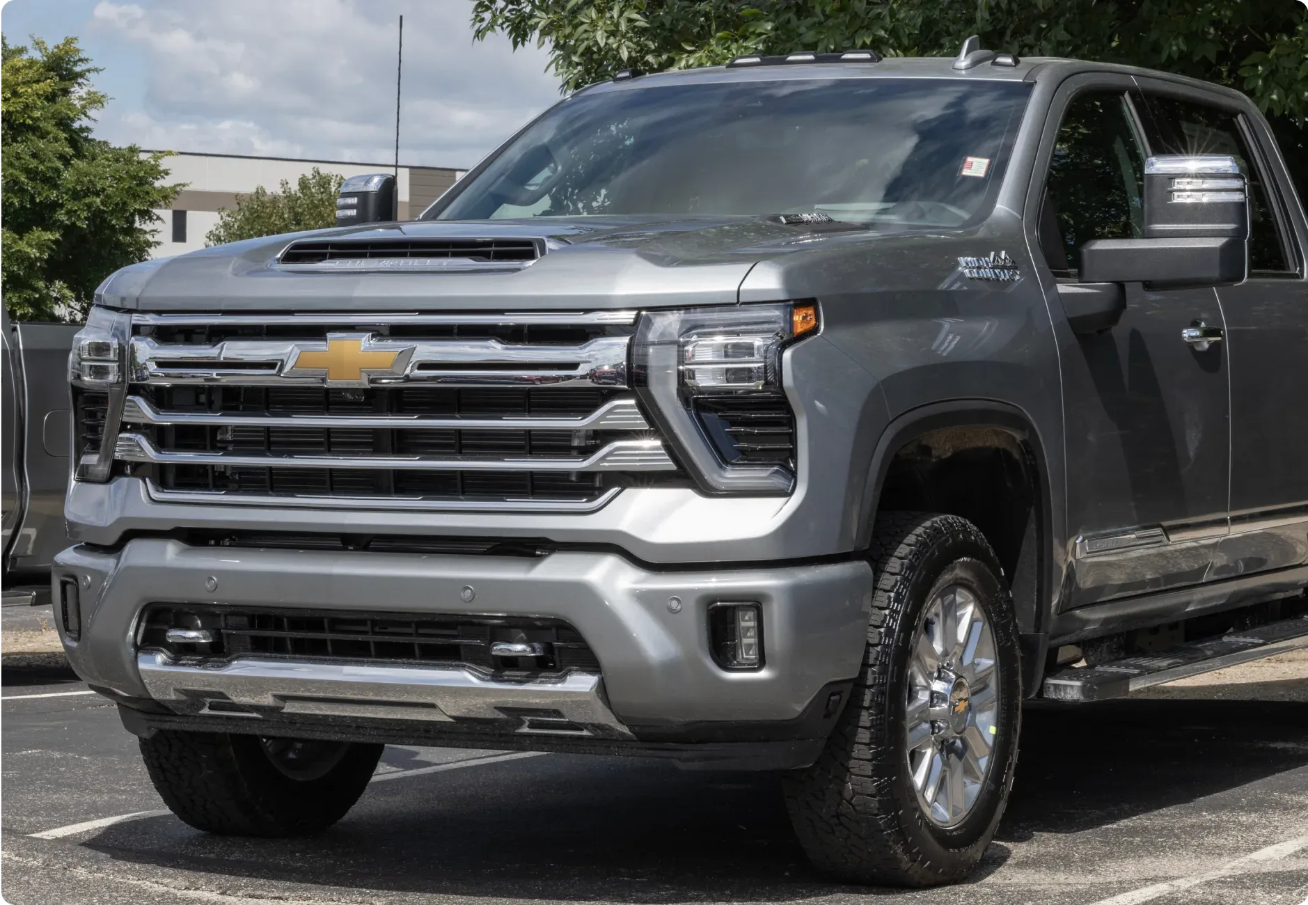 1023 Diesel & Fleet: silver Chevrolet pickup truck with a hood scoop and prominent front grille parked in a lot on a clear, sunny day.