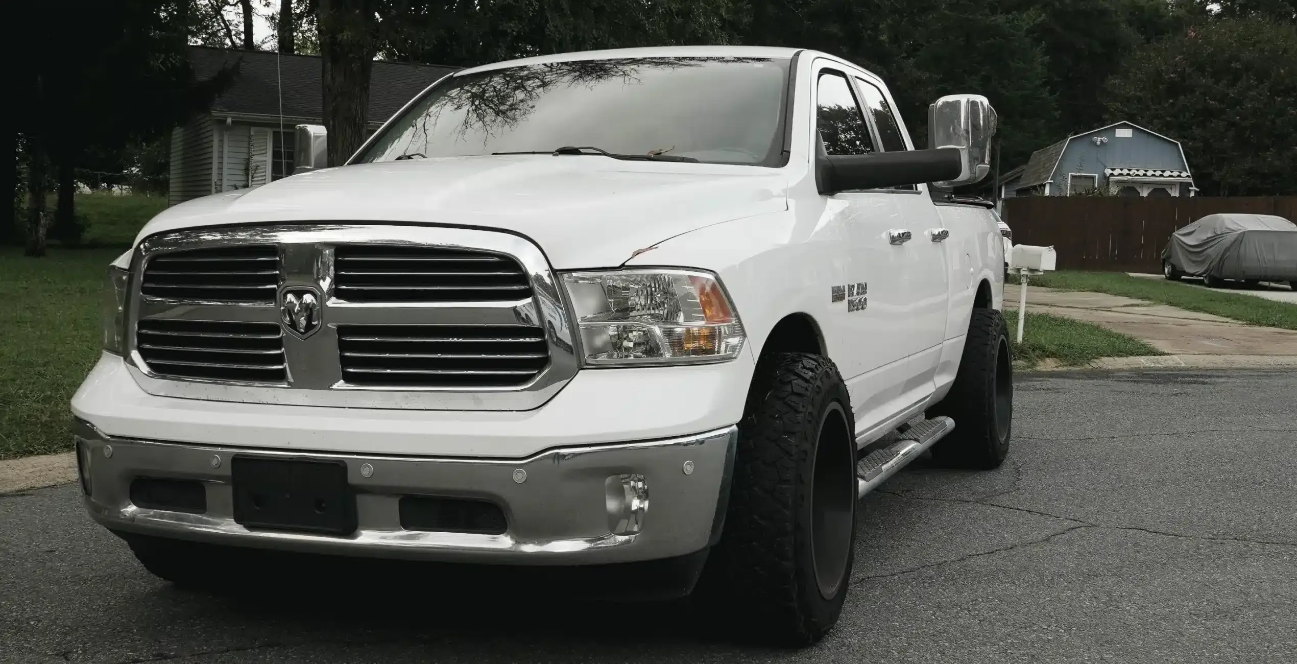 Diesel repair in Palmer, AK at 1023 Diesel & Fleet: a white pickup truck with large tires and chrome accents parked at an angle on a residential street.